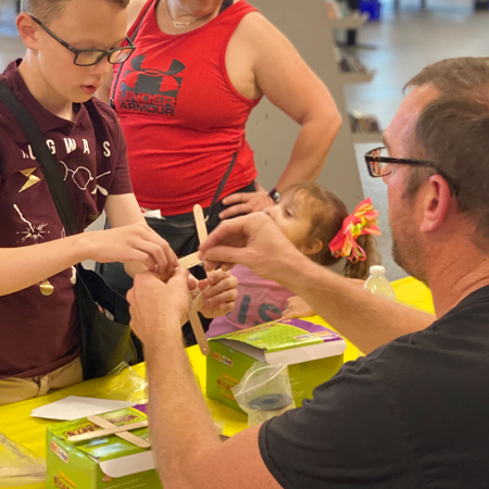 Photo: TEacher helping student with art project