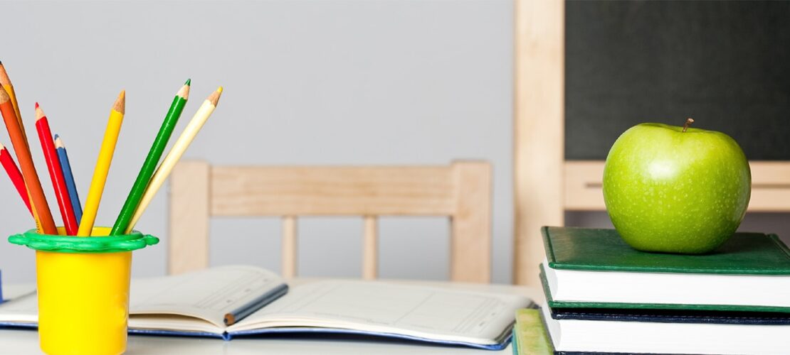 Photo: Pencils and an apple on teacher's desk